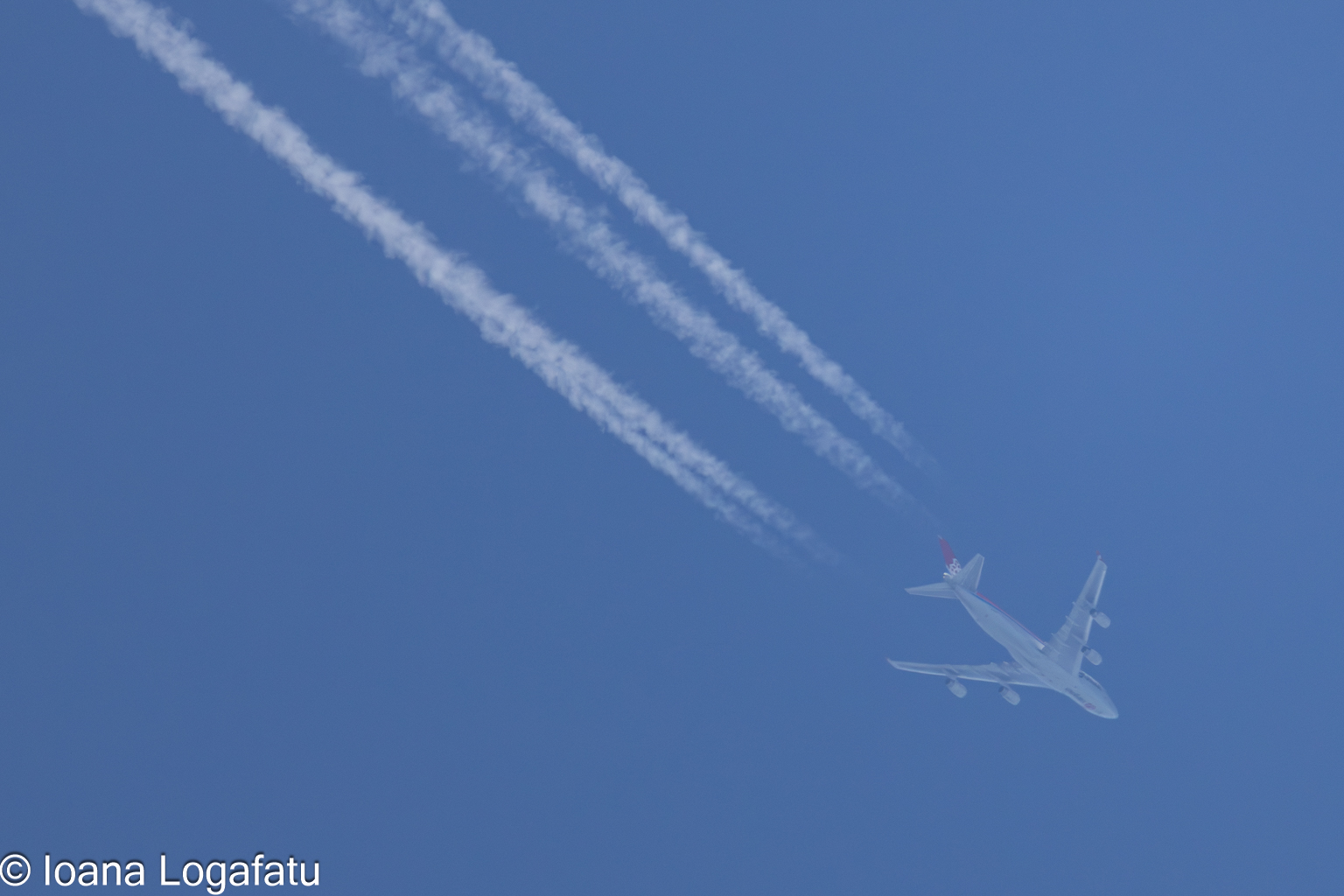 Airplane soaring through a clear blue sky